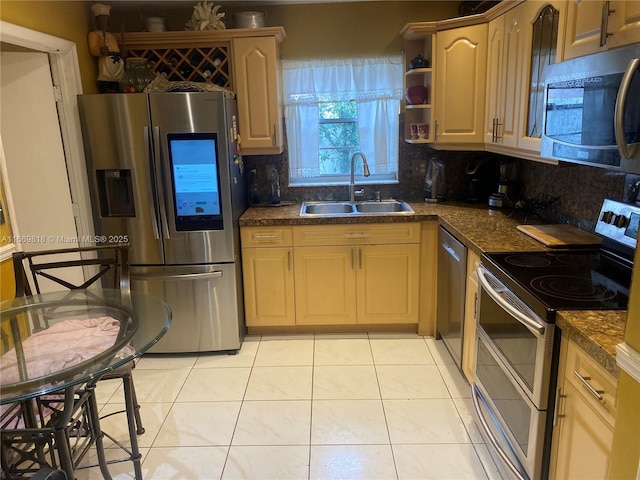 kitchen featuring dark countertops, appliances with stainless steel finishes, backsplash, and a sink