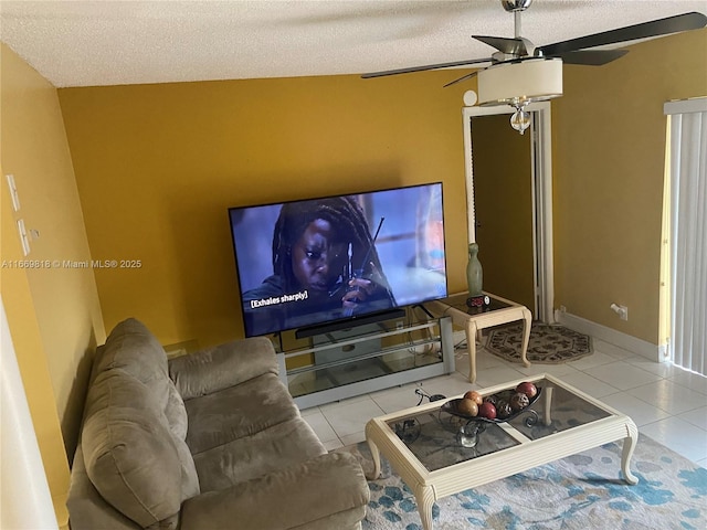 cinema room with ceiling fan, a textured ceiling, baseboards, and tile patterned floors