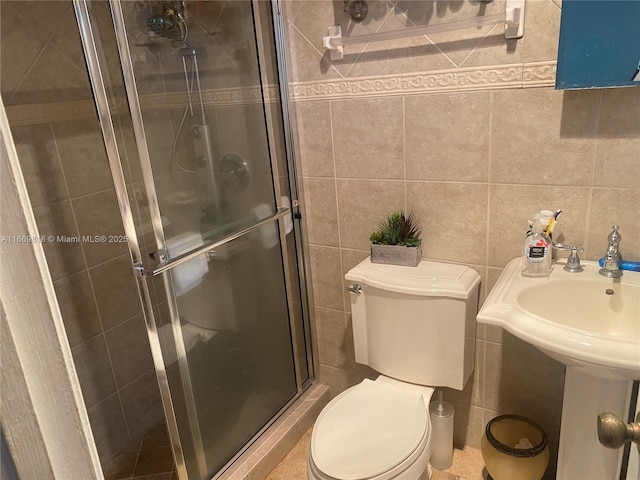 full bath with a stall shower, toilet, and tile walls