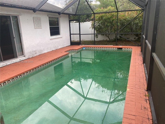 outdoor pool featuring a patio area and glass enclosure