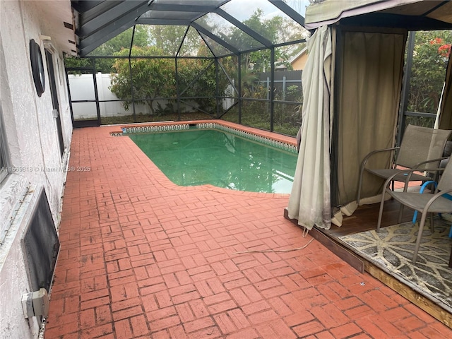 view of swimming pool featuring a fenced in pool, glass enclosure, a patio, and fence