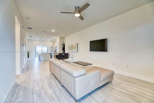 living room featuring light hardwood / wood-style floors and ceiling fan