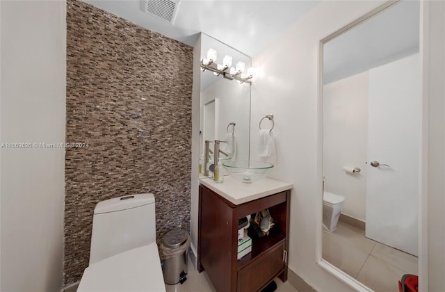 bathroom with vanity, toilet, and tile patterned floors