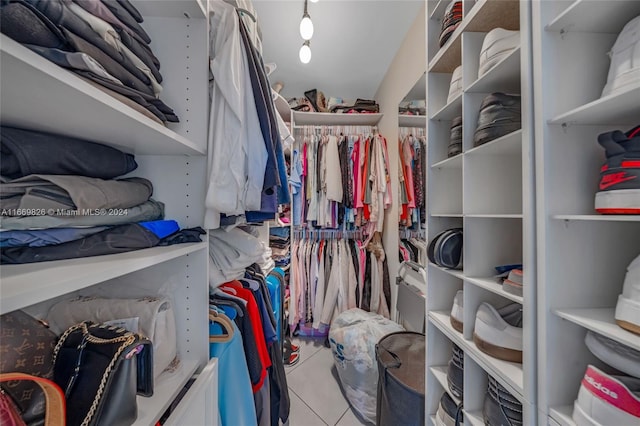 walk in closet with light tile patterned floors