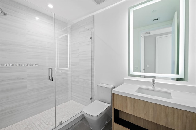 bathroom featuring vanity, a shower with shower door, and toilet