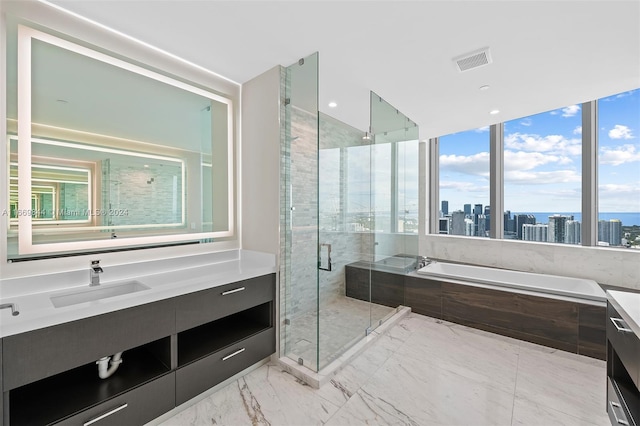 bathroom with shower with separate bathtub, a wealth of natural light, and vanity