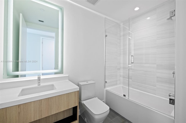 full bathroom with vanity, toilet, tile patterned floors, and bath / shower combo with glass door