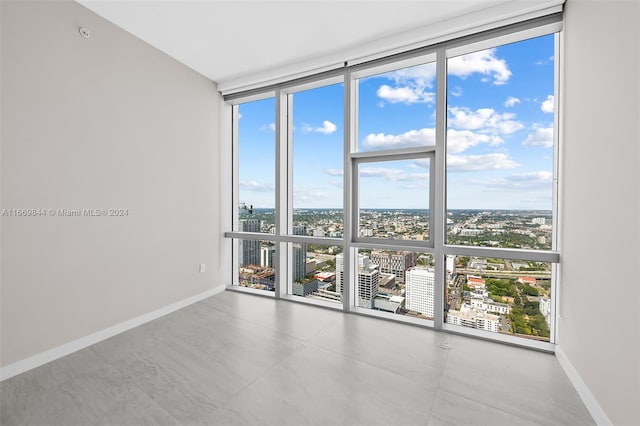 unfurnished room with floor to ceiling windows and concrete floors