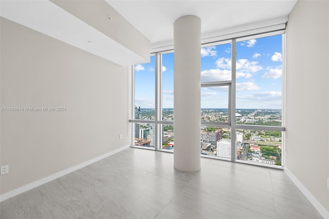 spare room with a wall of windows and concrete floors