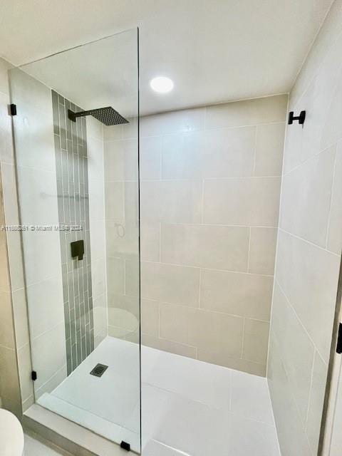 bathroom featuring a tile shower and toilet