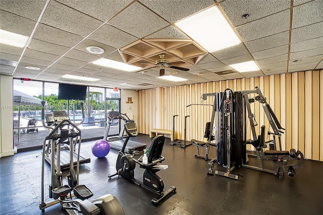 gym with ceiling fan and a paneled ceiling