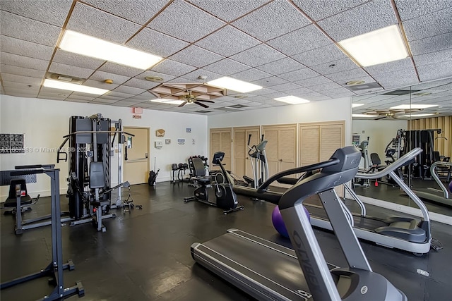 gym with ceiling fan and a paneled ceiling