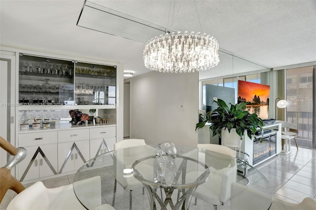 tiled dining space featuring a notable chandelier, a textured ceiling, and expansive windows