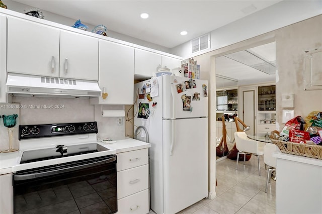 kitchen with white appliances, white cabinetry, and light tile patterned flooring