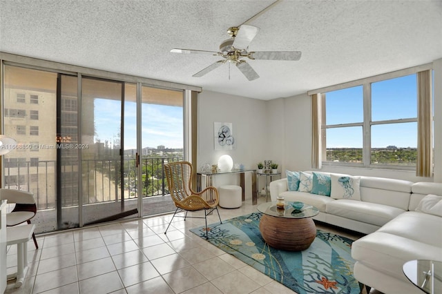 tiled living room featuring a wealth of natural light, a textured ceiling, a wall of windows, and ceiling fan