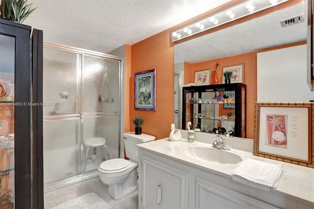 bathroom with a textured ceiling, a shower with door, vanity, and toilet