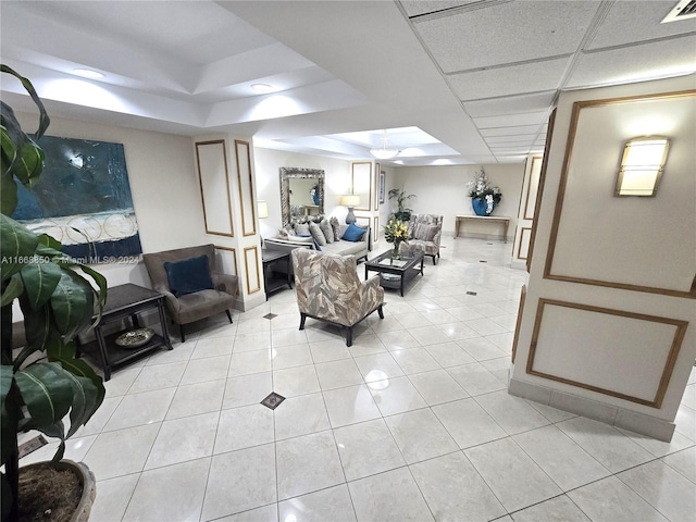 living room featuring a drop ceiling and light tile patterned floors