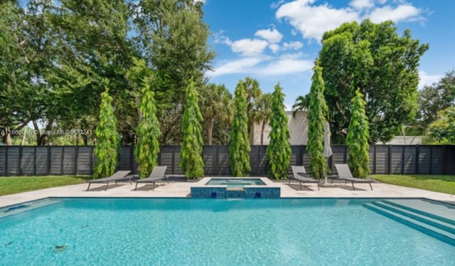 view of swimming pool with a patio and an in ground hot tub