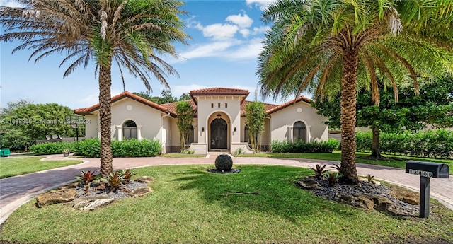 mediterranean / spanish-style house with a front yard