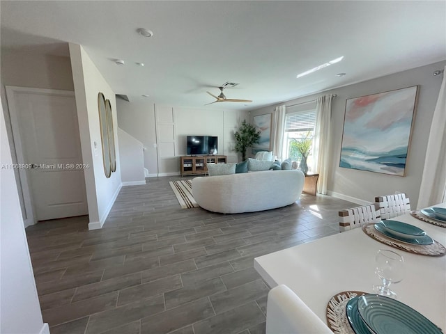 living room featuring ceiling fan and dark wood-type flooring