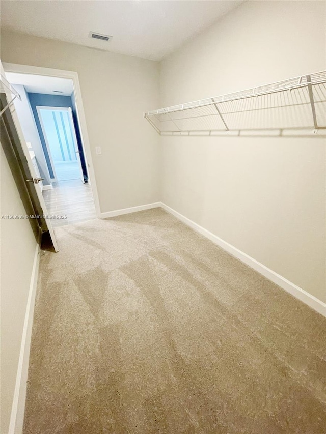 walk in closet with visible vents and carpet flooring