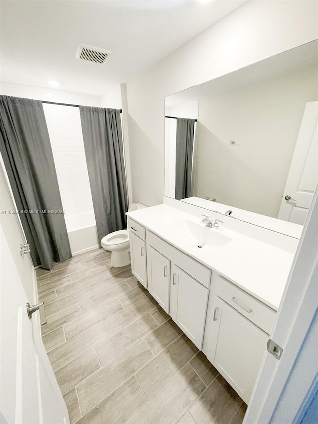 bathroom with visible vents, vanity, wood tiled floor, and toilet