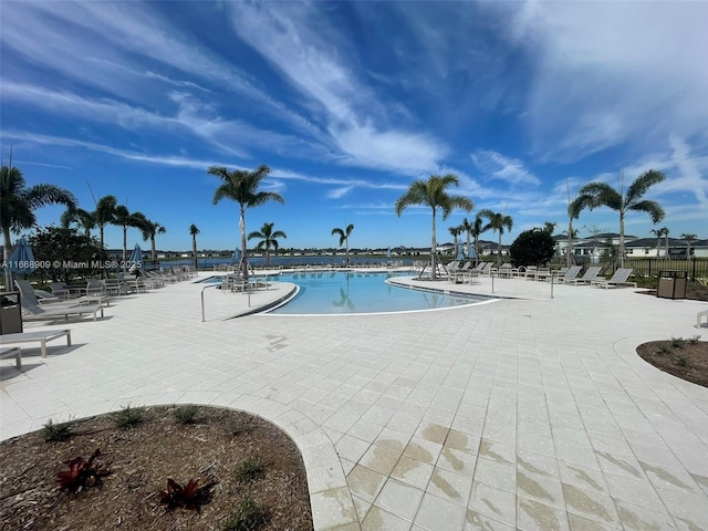 pool with a patio and fence