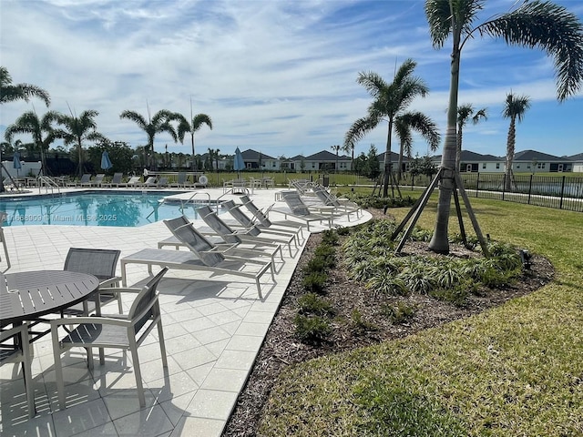 pool featuring a patio area, a lawn, and fence