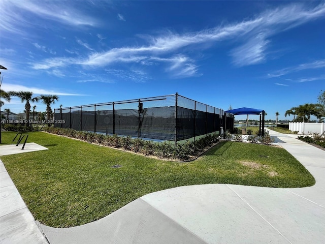 view of property's community featuring a lawn and fence