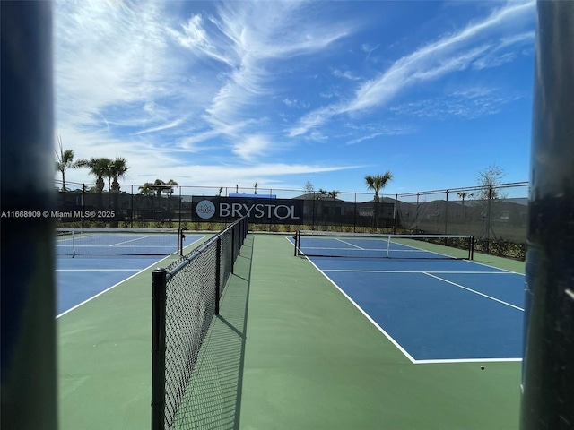 view of tennis court featuring fence