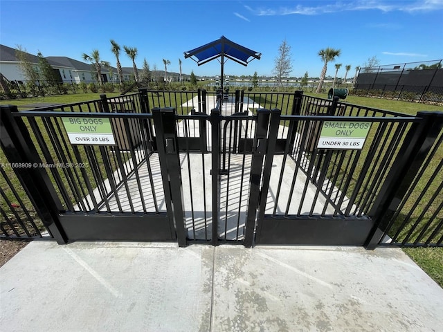 view of gate with a yard and fence