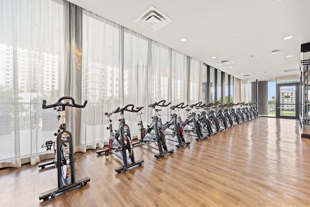 gym with light hardwood / wood-style floors and floor to ceiling windows