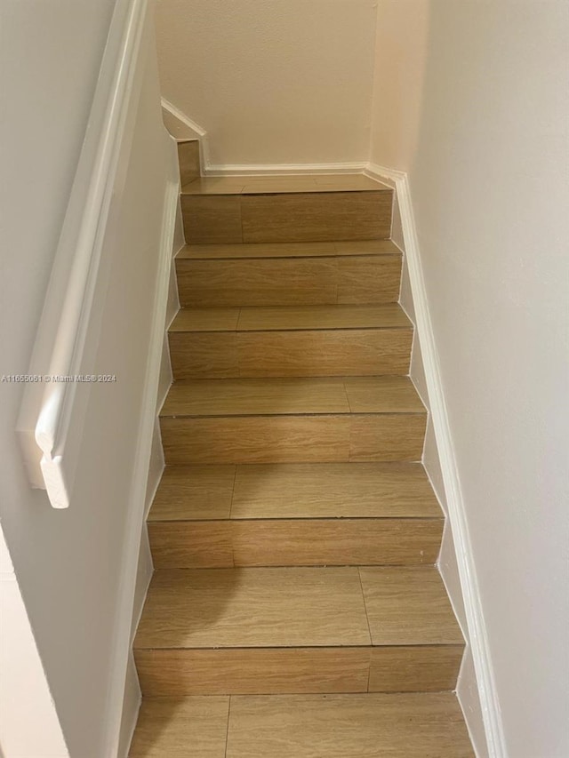 staircase with hardwood / wood-style flooring