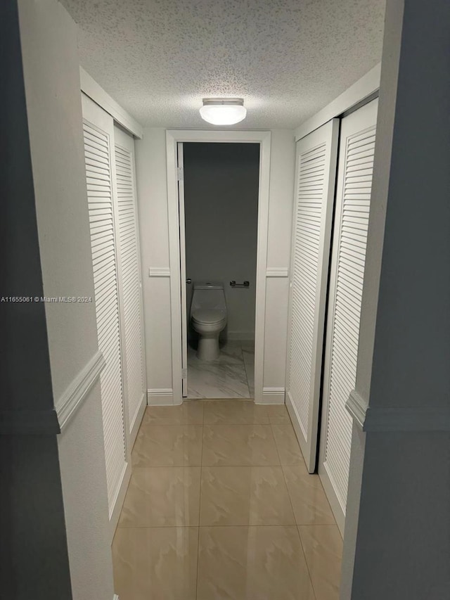 hallway with a textured ceiling