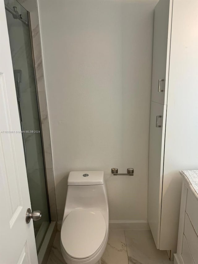 bathroom featuring vanity, toilet, and an enclosed shower