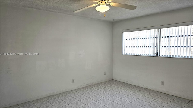 tiled empty room with a textured ceiling and ceiling fan