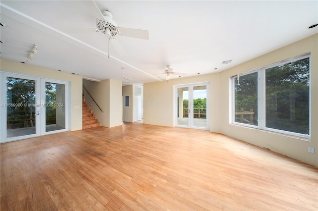 unfurnished living room with french doors, light hardwood / wood-style floors, and ceiling fan