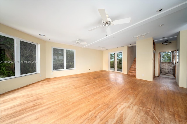 unfurnished living room with ceiling fan and light wood-type flooring