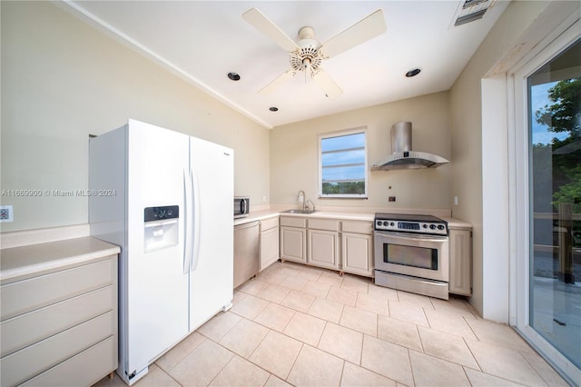 kitchen featuring ceiling fan, white cabinets, sink, wall chimney exhaust hood, and stainless steel appliances