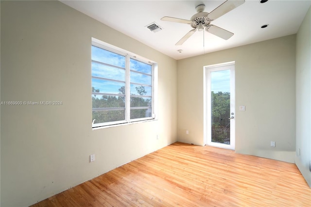 empty room featuring a wealth of natural light, light hardwood / wood-style floors, and ceiling fan