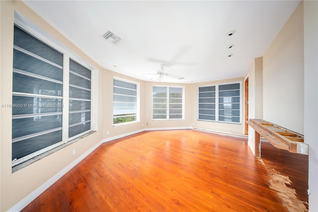 empty room with ceiling fan and hardwood / wood-style flooring