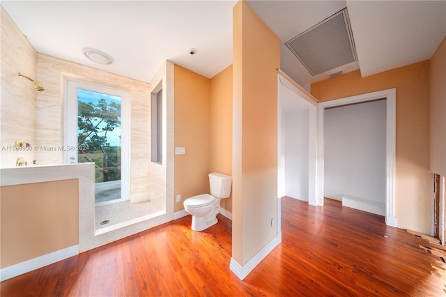 bathroom featuring walk in shower, hardwood / wood-style flooring, and toilet