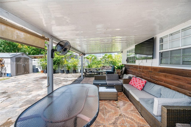 view of patio with an outdoor living space and a shed