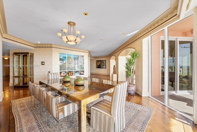 kitchen with light hardwood / wood-style flooring, decorative light fixtures, a water view, and dark stone countertops