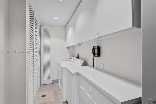 laundry room featuring light tile patterned flooring, independent washer and dryer, and cabinets