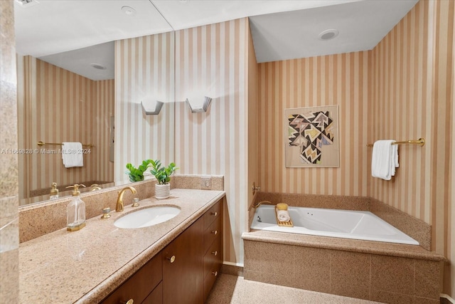 bathroom featuring vanity and a relaxing tiled tub