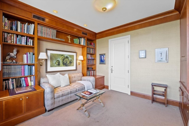 sitting room with ornamental molding and light colored carpet