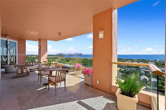 view of patio / terrace featuring a water view and a balcony