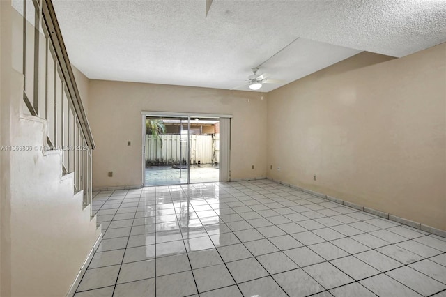 empty room with a textured ceiling, light tile patterned floors, and ceiling fan