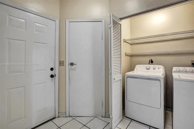 washroom featuring light tile patterned floors and washing machine and clothes dryer